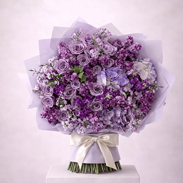 Lavender rose bouquet with purple filler flowers and a satin ribbon