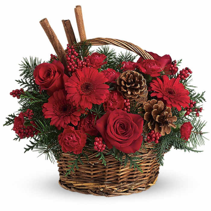 Red roses and gerbera daisies in a wicker basket with pinecones