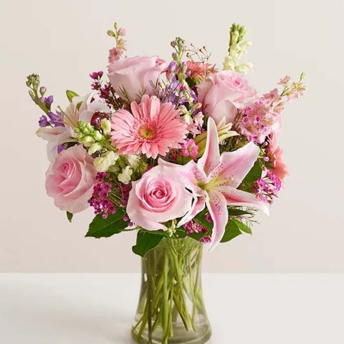 Pink mixed bouquet with roses and lilies in a clear glass vase