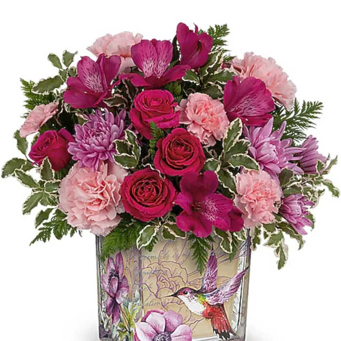 Pink and purple bouquet in a square glass vase with bird artwork