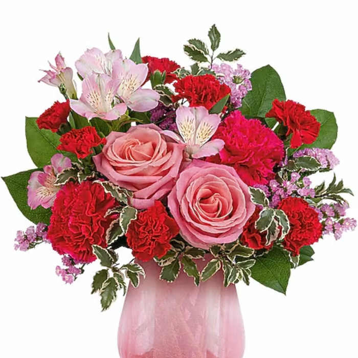 Pink roses and red carnations in a pink glass vase