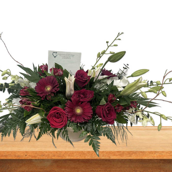 Long floral arrangement with burgundy roses and lilies in a vase
