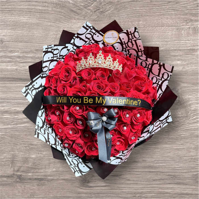 Heart-shaped bouquet of red roses with a tiara and ribbon