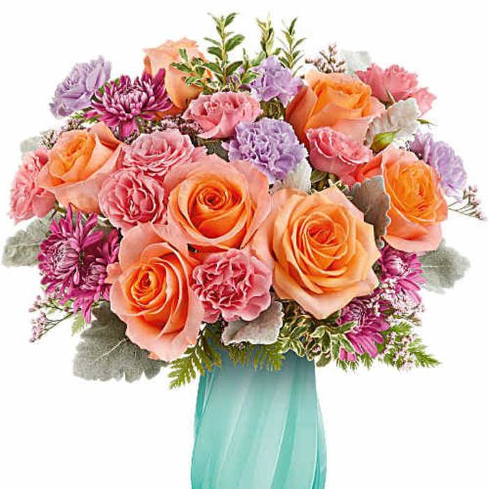 Bouquet of peach and pink roses in a turquoise vase