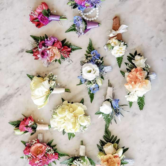 Assorted floral boutonnieres and corsages with ribbon accents