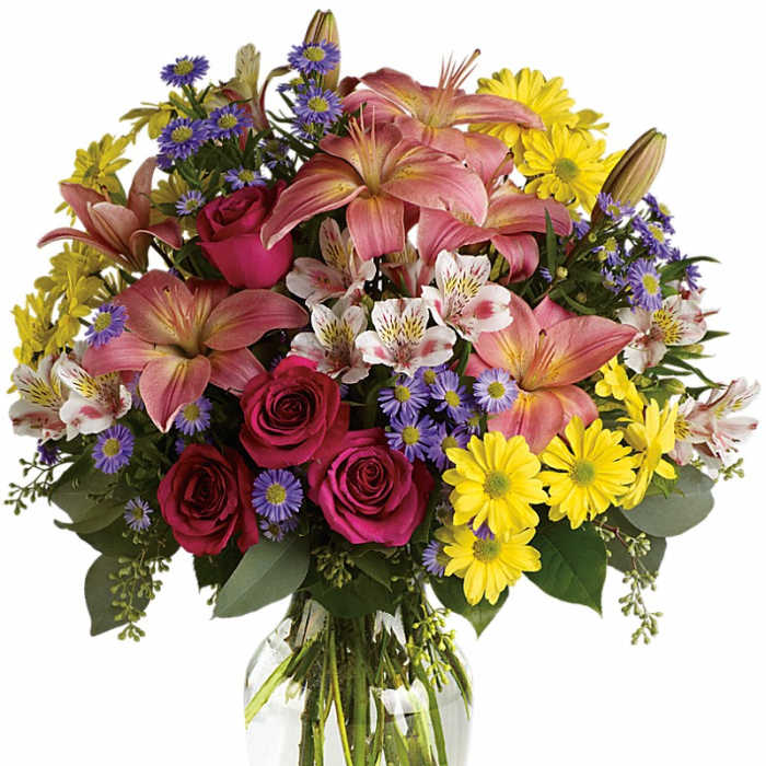Mixed bouquet of pink lilies, roses, and yellow daisies in a glass vase