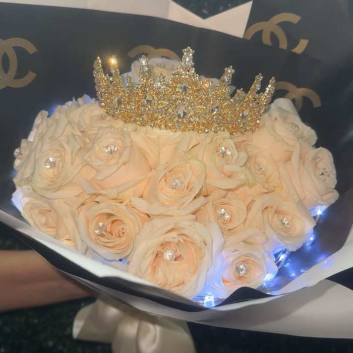 Cream rose bouquet with a jeweled crown topper
