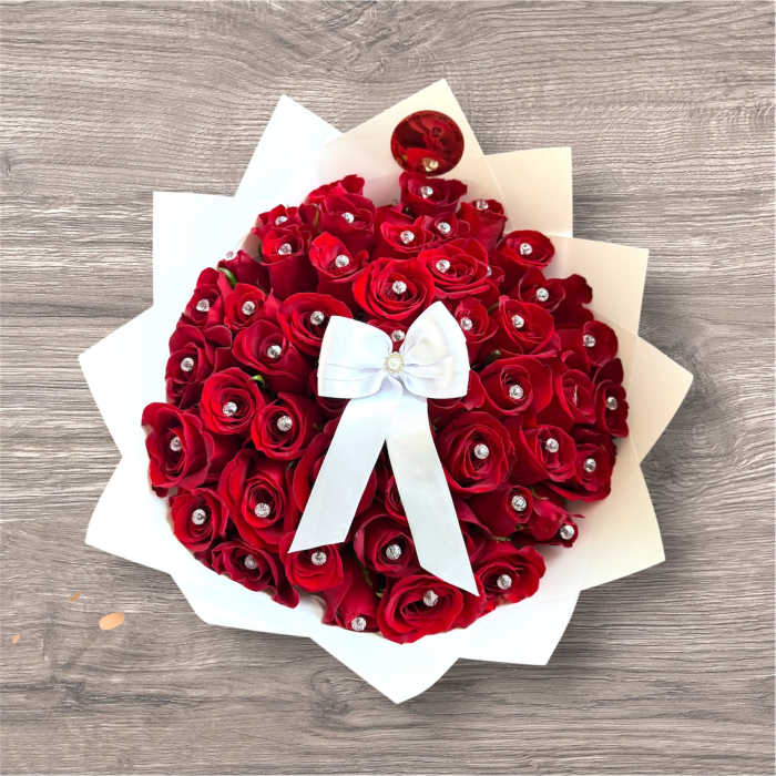 Bouquet of red roses with a white bow and paper wrap