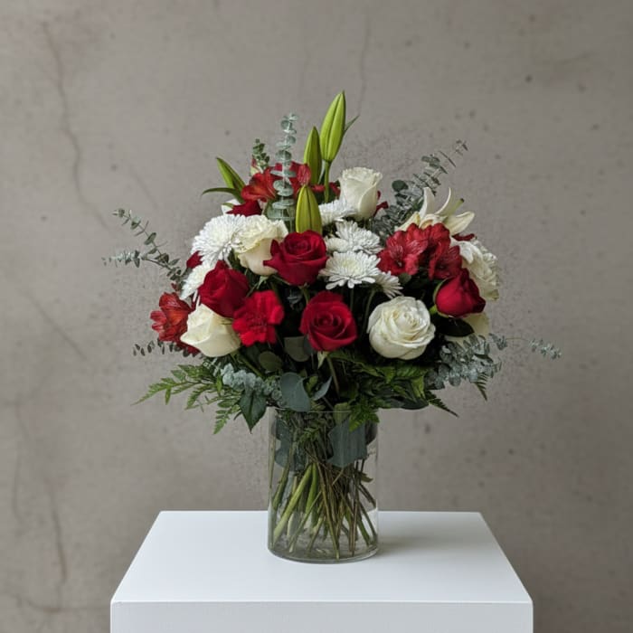 Red and white flower bouquet in a clear glass vase