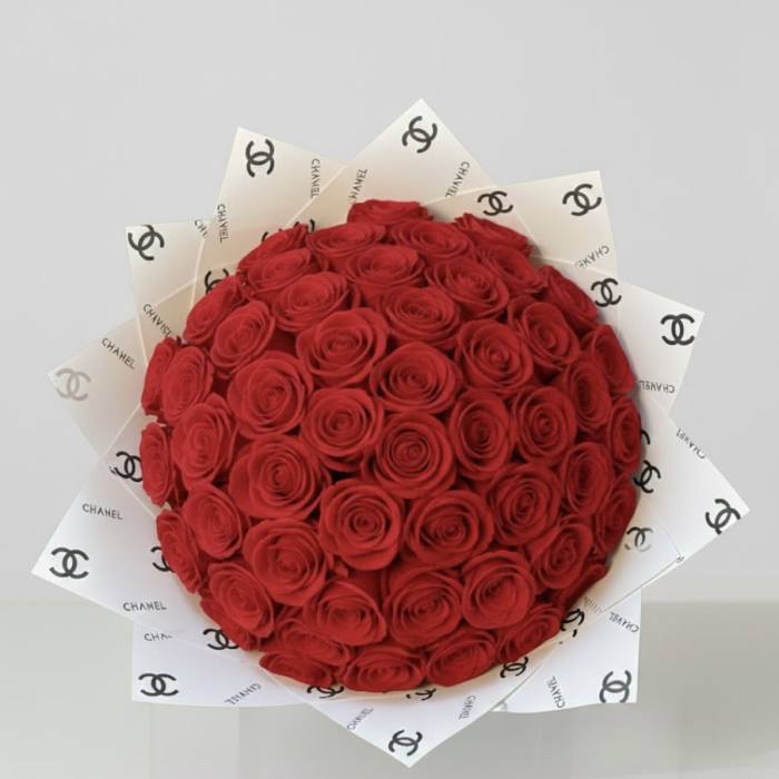 Round bouquet of red roses wrapped in white Chanel paper