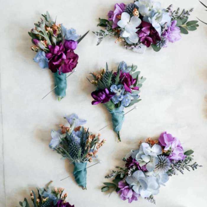 Small purple and blue boutonnieres with wrapped stems