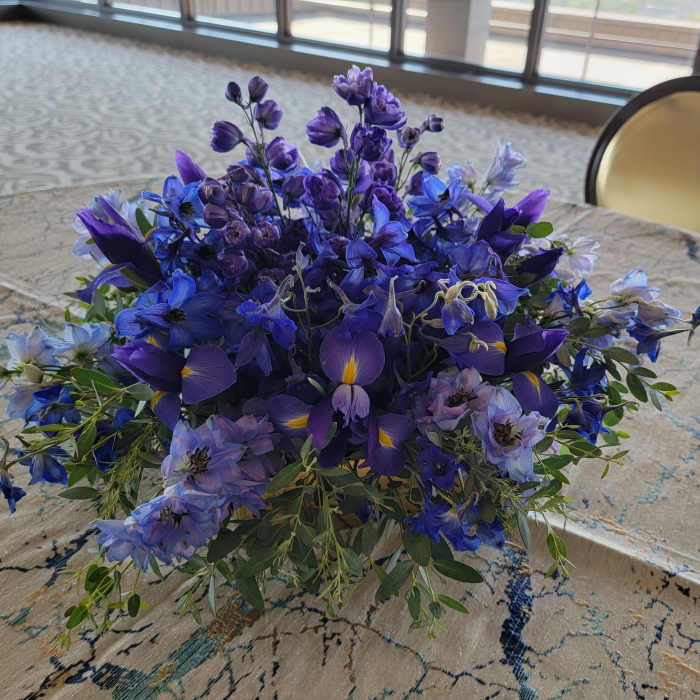 Low bouquet of blue and purple flowers on a table