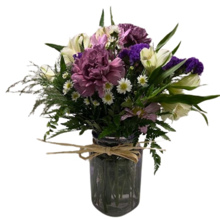 Mixed bouquet of purple and white flowers in a glass vase