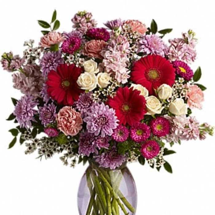 Mixed pink and purple bouquet in a lavender glass vase