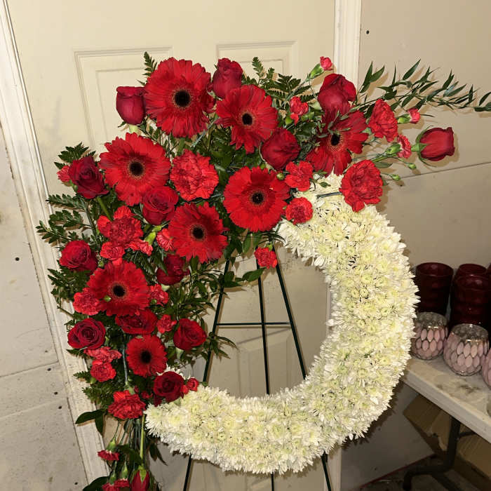 Heart-shaped floral wreath with red roses, gerbera daisies, and white chrysanthemums