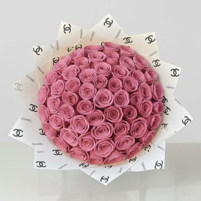Bouquet of pink roses wrapped in Chanel-branded paper