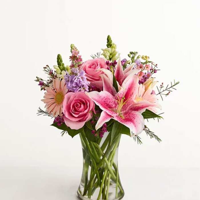 Pink roses and lilies in a clear glass vase
