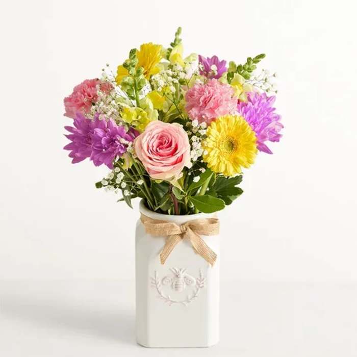 Mixed bouquet in a white vase with a burlap bow