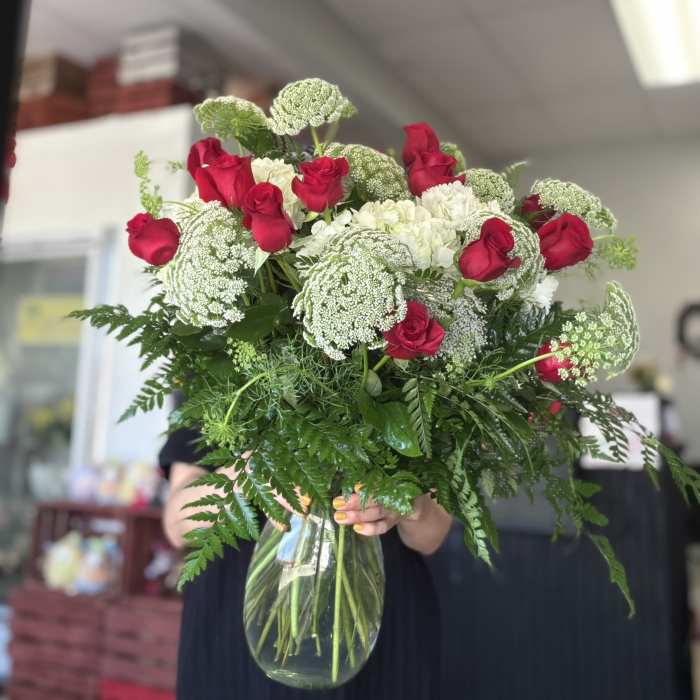 Bouquet of red roses and white flowers in a clear glass vase