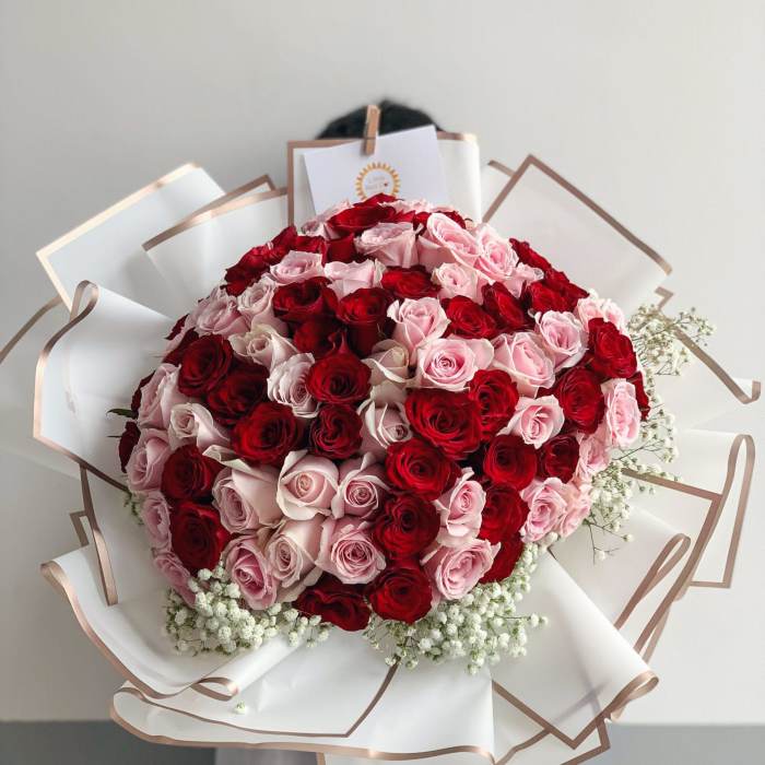 Large bouquet of red and pink roses wrapped in white paper