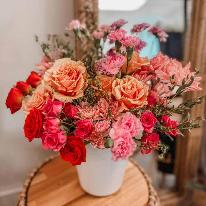 Bouquet of pink and peach roses in a white vase