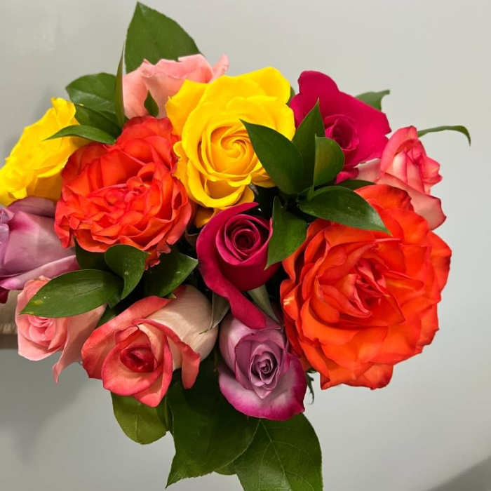 Bouquet of multicolored roses with green leaves