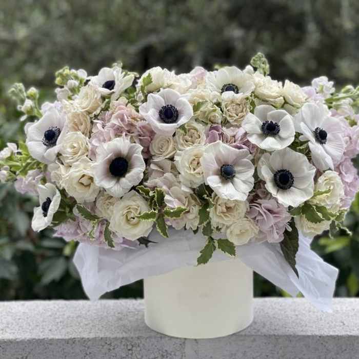 White and blush floral arrangement in a white vase
