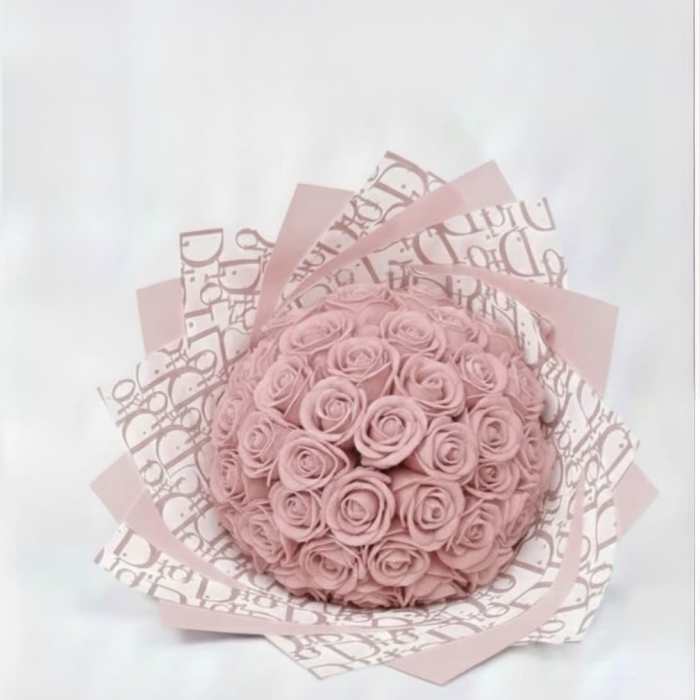 Round bouquet of pink roses wrapped in patterned pink paper