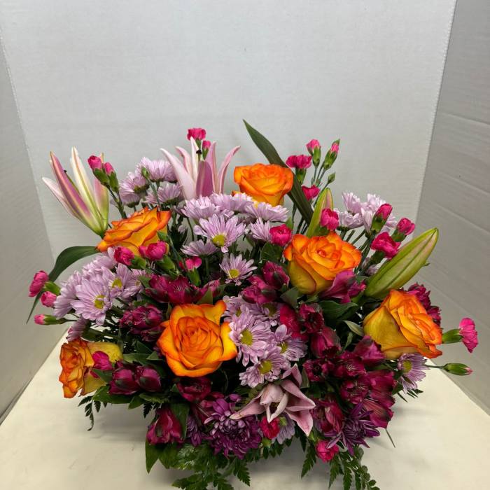 Mixed bouquet with orange roses, pink lilies, and purple daisies