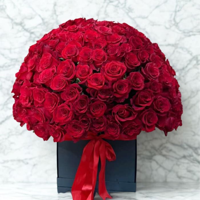 Large bouquet of red roses in a black box with a red ribbon