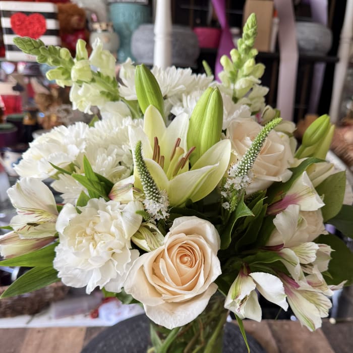 Bouquet of white and blush flowers in a clear glass vase