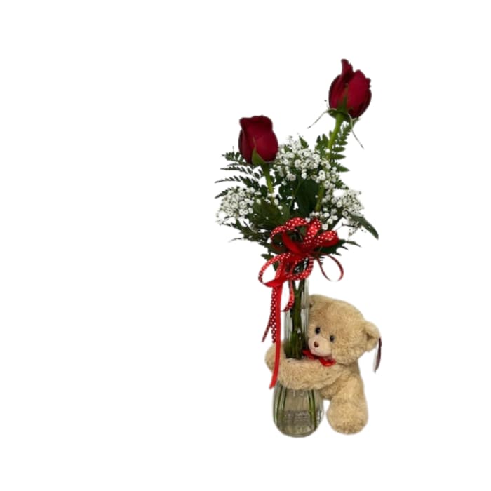Two red roses in a glass vase with baby's breath and a teddy bear