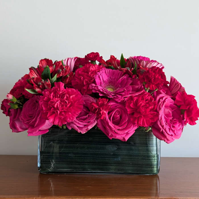 Pink and red mixed bouquet in a rectangular glass vase