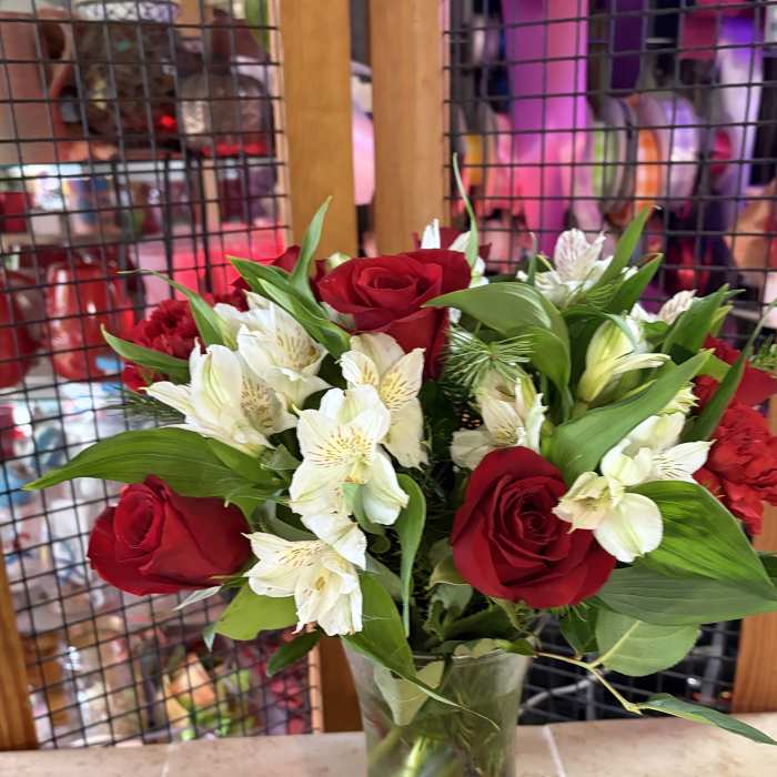 Red roses and white alstroemeria in a clear glass vase