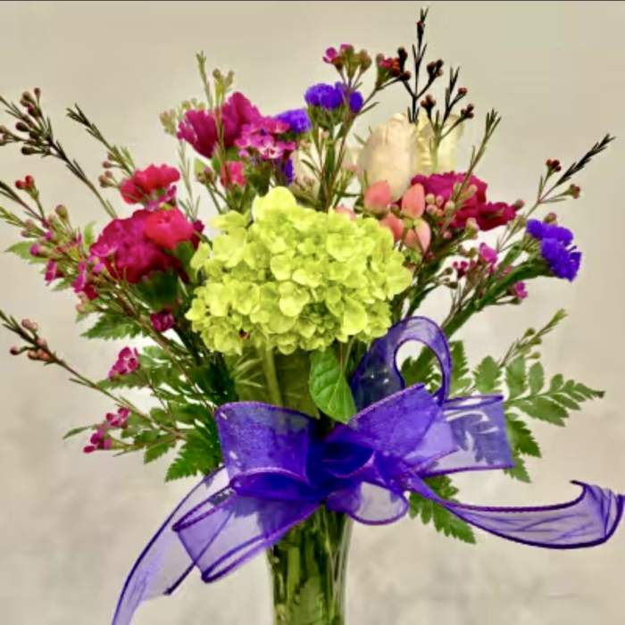 Mixed bouquet with lime hydrangea and pink, purple flowers in a glass vase