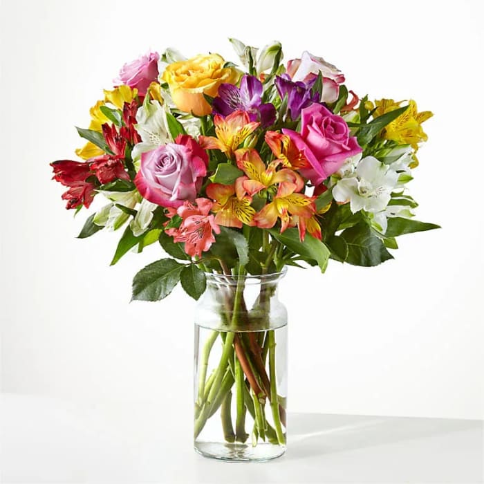 Mixed bouquet of colorful flowers in a clear glass vase