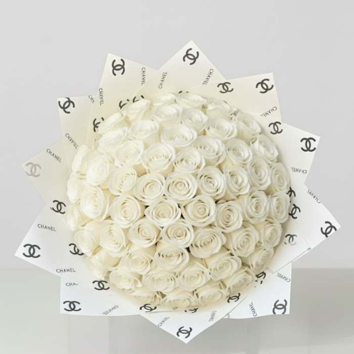 Bouquet of white roses wrapped in Chanel-logo paper