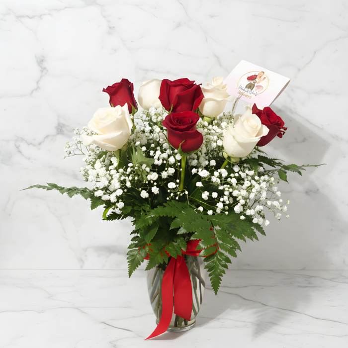 Red and white roses in a glass vase with baby's breath
