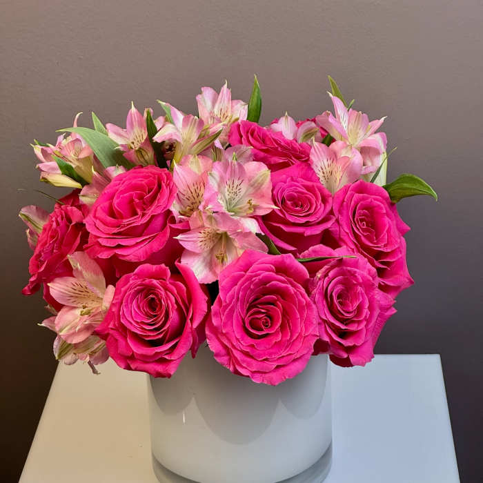 Pink roses and pale pink alstroemeria in a white vase