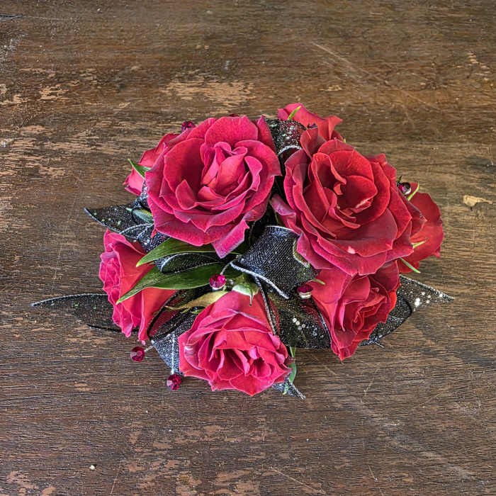 Small bouquet of bright pink roses with black ribbon accents