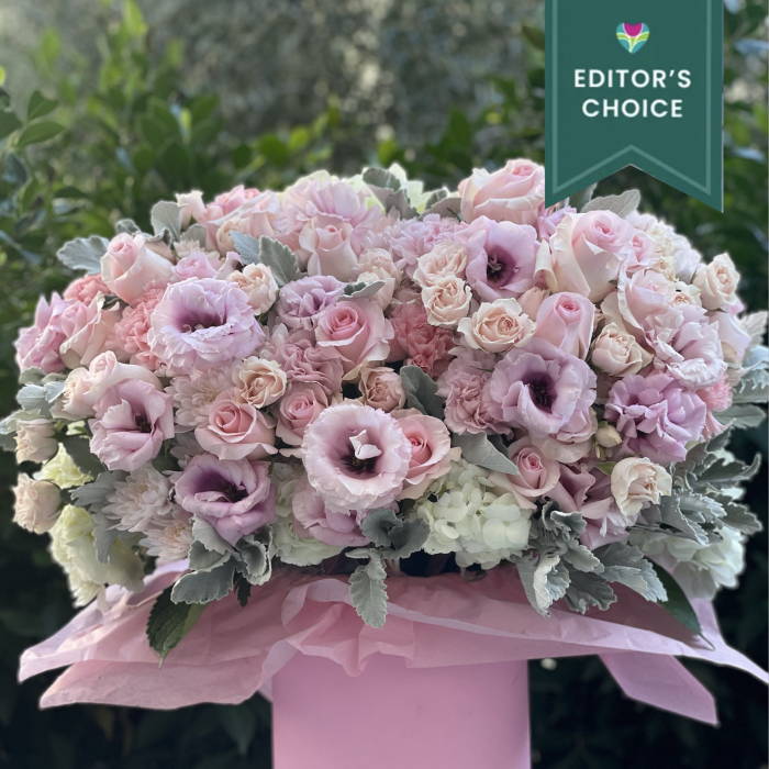 Large pastel pink and white floral arrangement in a round pink hatbox