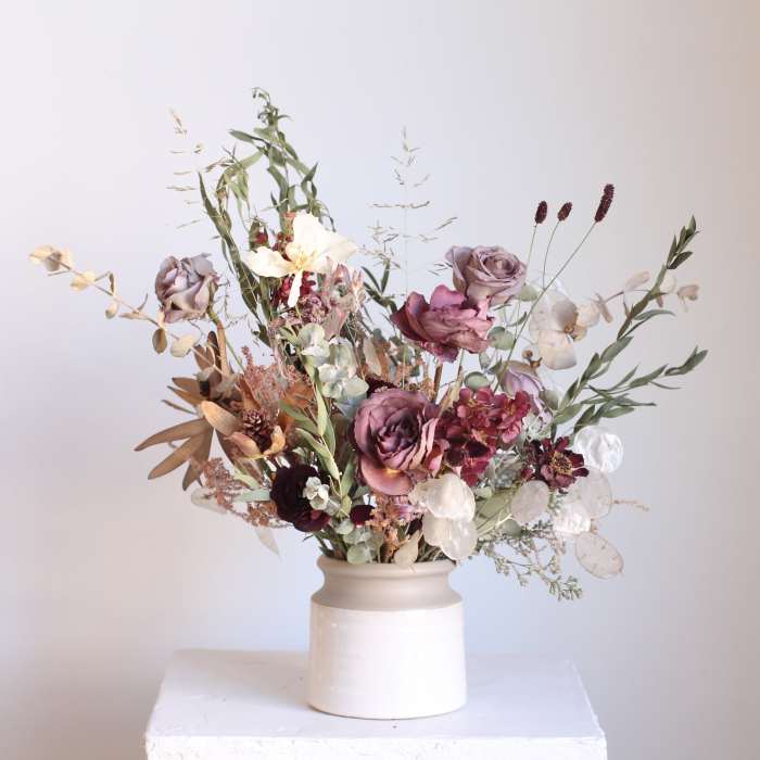 Mixed bouquet in a white ceramic vase with mauve and cream flowers