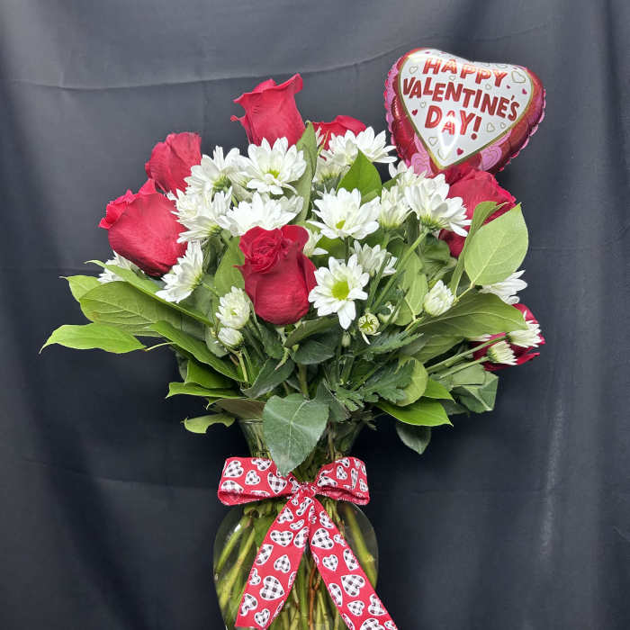 Red roses and white daisies in a glass vase with a Valentine heart balloon