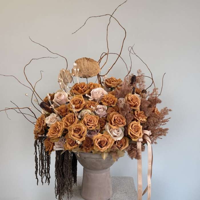 Large bouquet of peach and blush roses in a tall vase