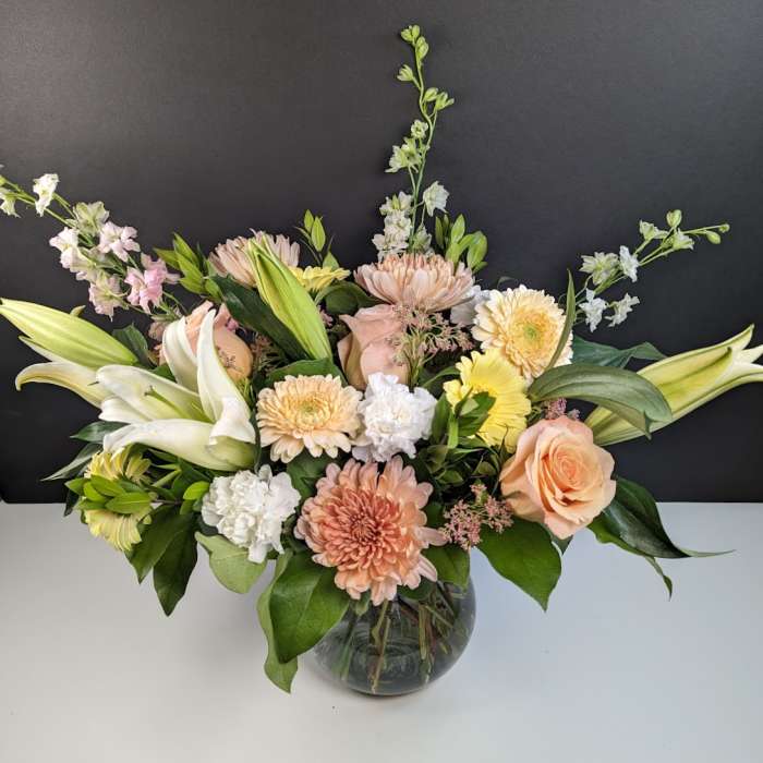 Mixed pastel bouquet in a round glass vase