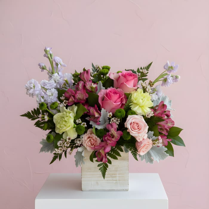 Pink and white mixed flower arrangement in a wooden box