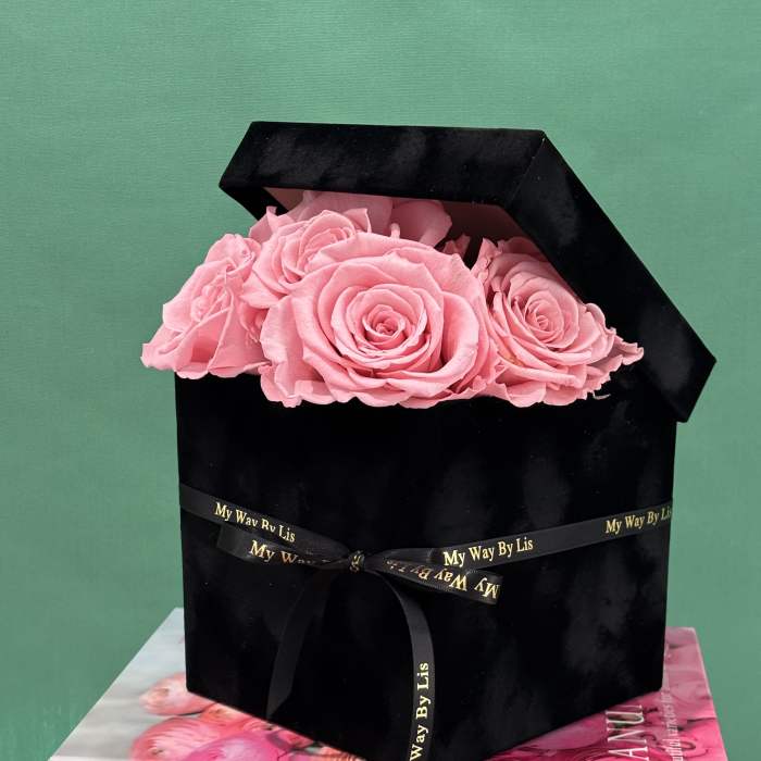 Pink roses in a black box tied with a ribbon