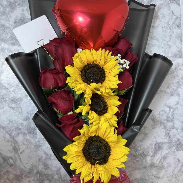 Bouquet of red roses and sunflowers with a red heart balloon