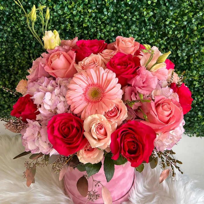 Pink and red rose bouquet with a gerbera daisy in a pink hatbox