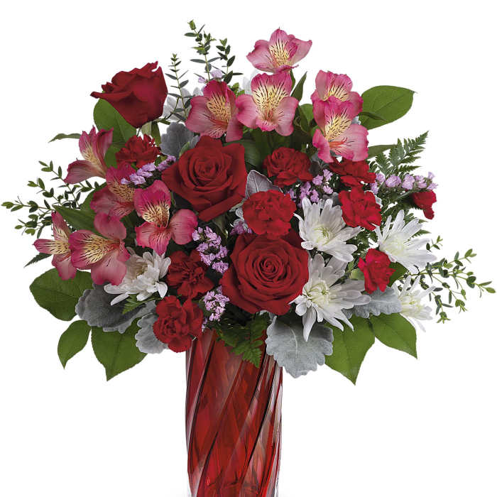 Red roses and pink alstroemeria in a red glass vase